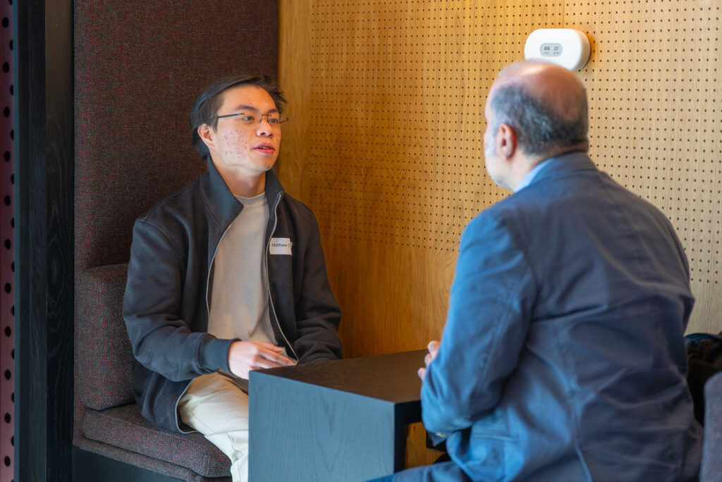 Two people in conversation in a meeting booth at the Hub