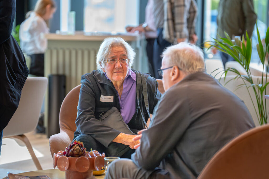 Two attendees talking over coffee at the Hub