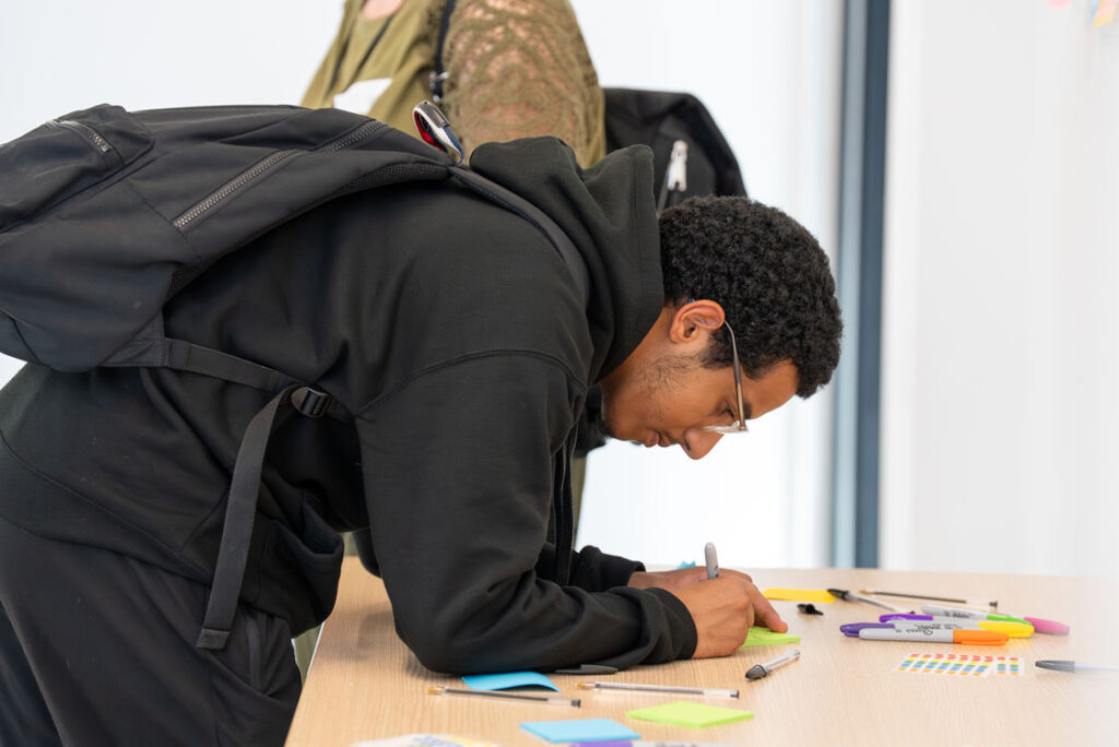 A participant writing notes during a workshop