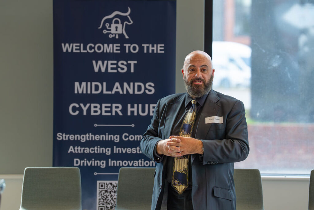 A speaker presenting beside the Hub welcome banner