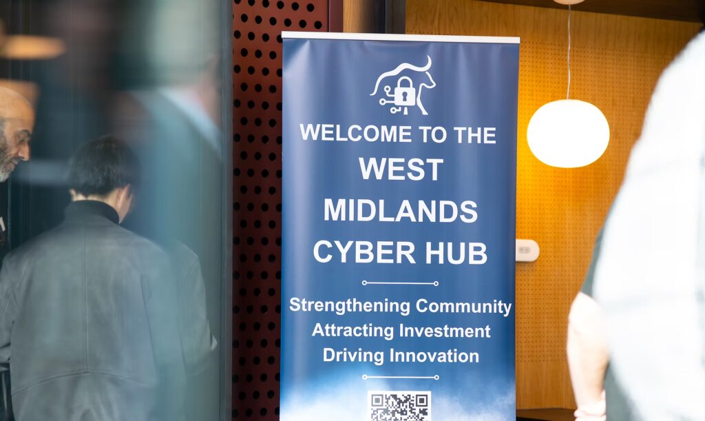 Visitors arriving at the West Midlands Cyber Hub beside the welcome banner